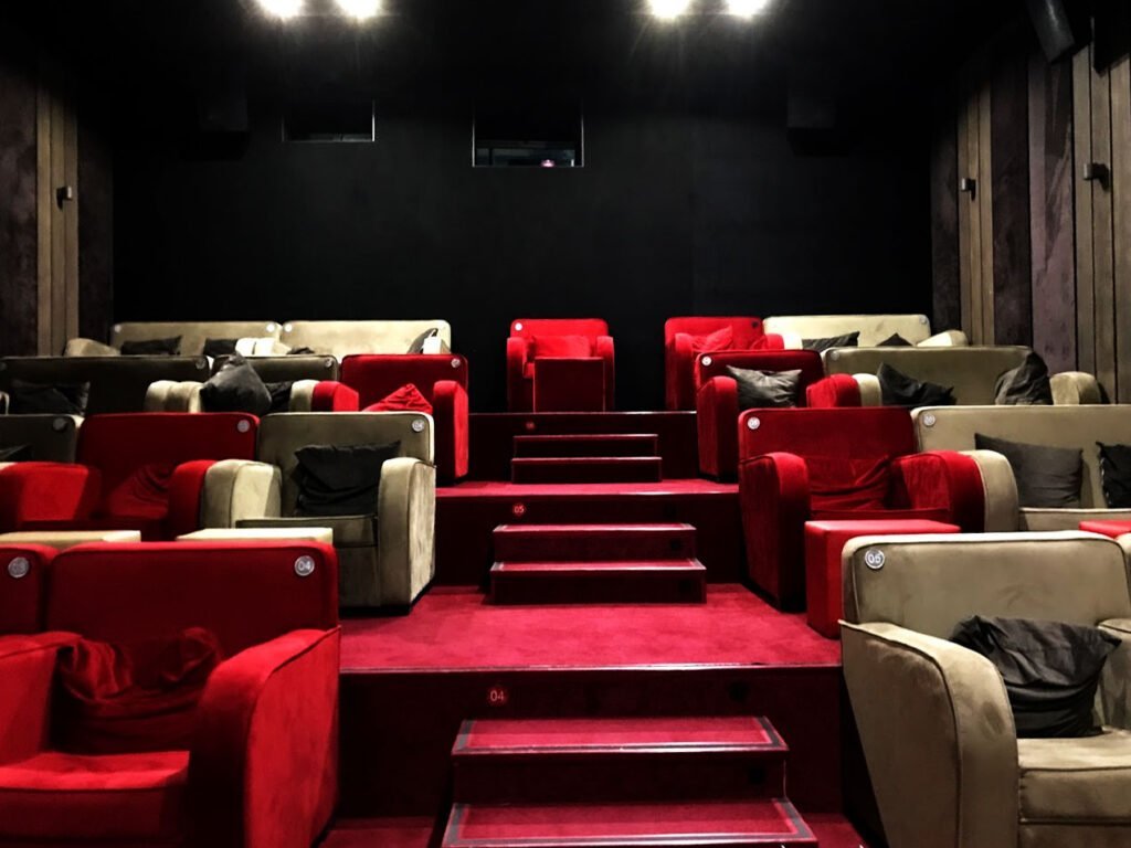 A cosy cinema hall in the Amirani Cinema in Tbilisi with red and beige armchairs, equipped with cushions for extra comfort.