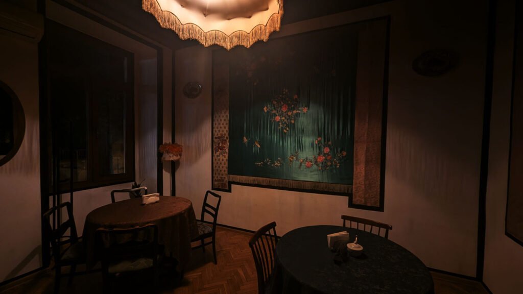 Intimate dining room at Nair Nairi Restaurant in Tbilisi, Georgia, with subdued lighting, floral wallpaper and traditional wooden tables.