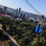 the blue cable car from vake park to turtle lake. in the background you can see the cityscape of tbilisi