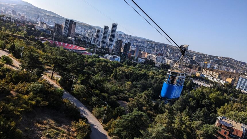 the blue cable car from vake park to turtle lake. in the background you can see the cityscape of tbilisi